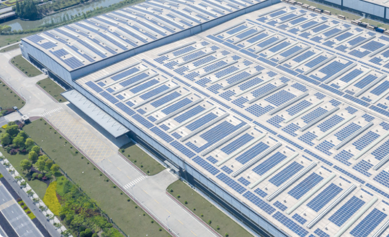 Industrial facility with large solar panel installation on the roof, showcasing sustainable energy use and renewable energy generation for industrial operations.
