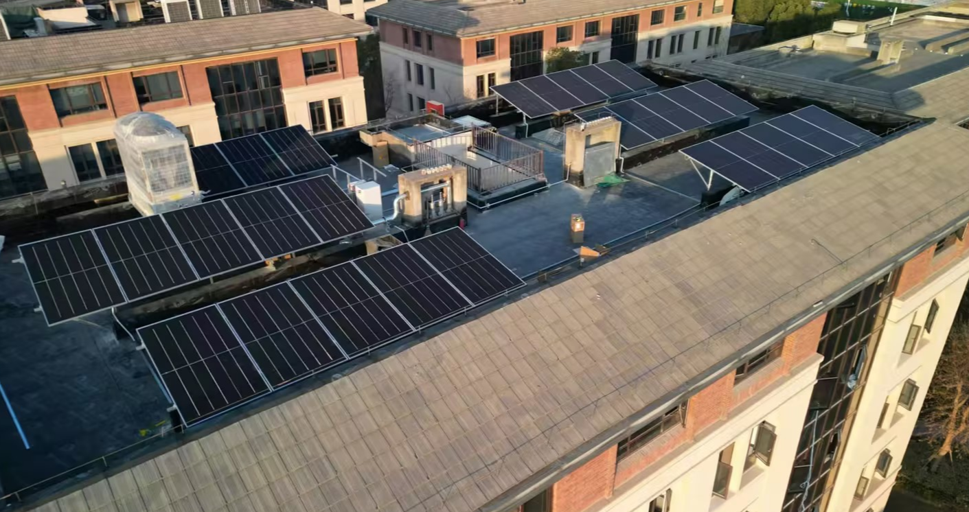 Aerial view of a rooftop solar PV system installed on a commercial building with multiple black monocrystalline panels neatly arranged for clean energy generation